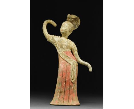 Ca. 618-907 AD. A hollow-moulded terracotta female dancer depicted with her upper body slightly bent to the side, with her ri