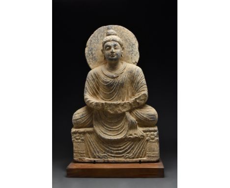 Ca. 200-300 AD.A seated schist figure of Buddha atop a platform flanked by two columns. The facial features are carefully mod
