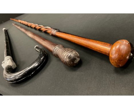 A late 19th century cane, ring turned pommel. 92cm high;  an ebonised shooting stick;  a wrythen cane, 142cm long (3)