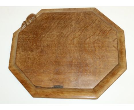 Robert Mouseman Thompson of Kilburn - an oak octagonal bread board, moulded edge carved with signature mouse, 30cm x 25.5cm 