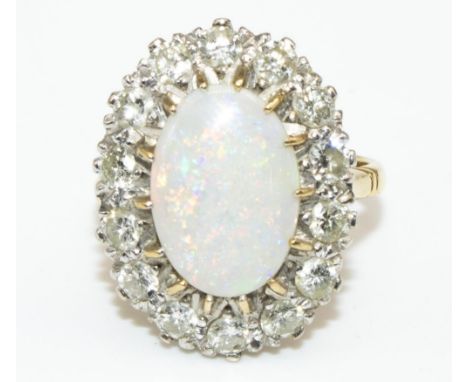 18ct yellow gold opal and diamond cluster ring, the large cabochon opal surrounded by fourteen brilliant cut diamonds, stampe