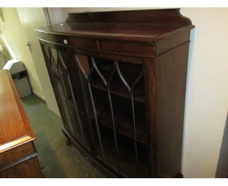 1920's Oak bow front bookcase with two bar glazed doors raised on cabriole claw and ball supports