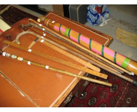 Walking stick with figural carved handle, two rules, a quantity of other walking sticks and a rain stick