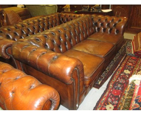 20th Century brown button upholstered leather three seat Chesterfield sofa with loose cushions, on bun supports