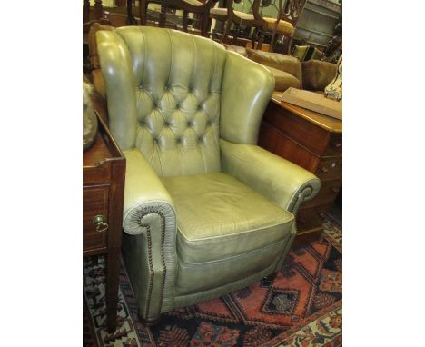 20th Century green leather button upholstered wing back armchair raised on bun front supports