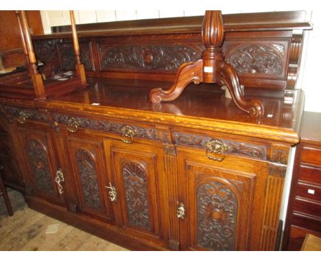 Large Victorian carved dark oak sideboard with a low shelf back above three drawers and four panelled doors