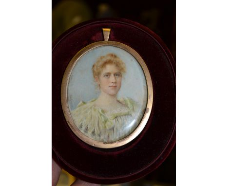 Early 20th Century watercolour, portrait, miniature of a lady wearing a green dress, housed in an oval red velvet case