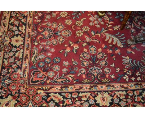 Persian design carpet with all-over floral pattern on a red ground with borders (two cuts to one edge)