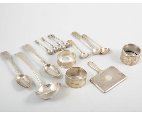 A collection of silver spoons, a sauce ladle, tea and condiment spoons, a silver engine turned handbag mirror, three napkin r