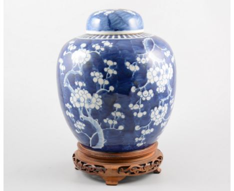 Chinese blue and white ginger jar, painted with flowering prunus, red seal to inside of lid with wooden stand, 30cm.