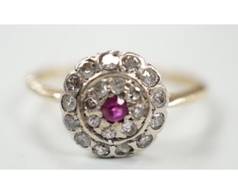 An early to mid 20th century, yellow metal ruby and diamond set target cluster ring, size P, gross weight 2.8 grams.
