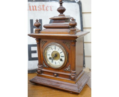 A 19th century German walnut mantel clock with key and pendulum, 40cm tall