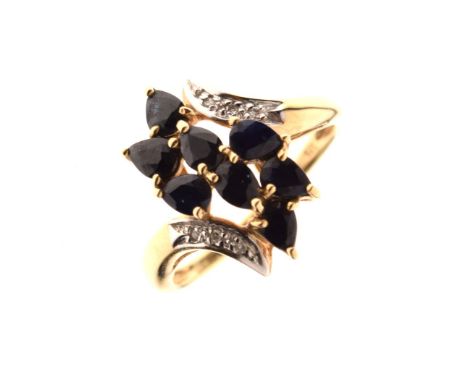 Yellow metal dress ring set S-shaped arrangement of faceted teardrop-form dark stones between diamond chips to shoulders, sha