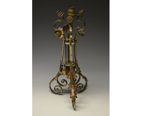 An Arts and Crafts wrought iron tripod table lamp in the style of Benson, mounted with three worked copper flowerheads and sp