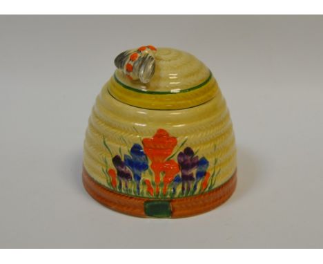 A Clarice Cliff Crocus pattern Bee skep preserve pot and cover, painted in colours with crocuses, banded in yellow and tan, b