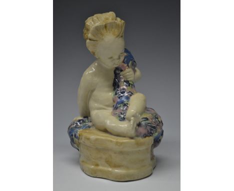 A Hammersmith Pottery figure, Buster Boy, modelled by Phoebe Stabler, modelled as an infant astride a quatrefoil outcrop, hol