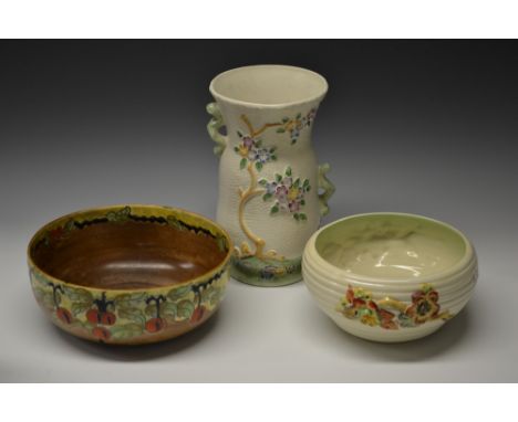 A Clarice Cliff ribbed cylindrical bowl, relief moulded with flowering branches, in autumnal tones on cream ground, 22cm diam