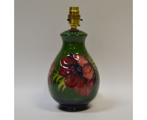 A Moorcroft Anemone pattern baluster table lamp, tube lined with large flowerheads in ones of red and blue on a green ground,