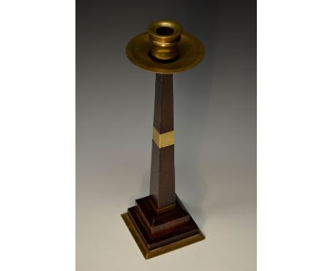 A French Art Deco rosewood table candlestick, in the style of Ruhlmann, brass sconce, spreading circular drip tray, tapering 