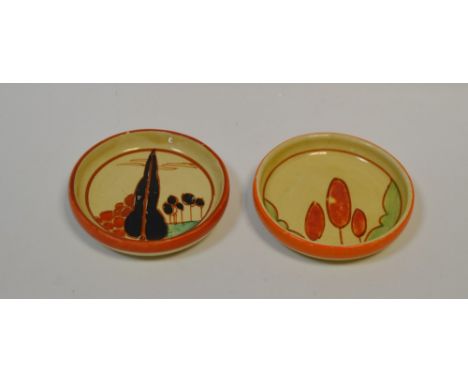 A Clarice Cliff pin dish, brightly decorated with a tall black tree ad others with bubble foliage in red and black, banded in