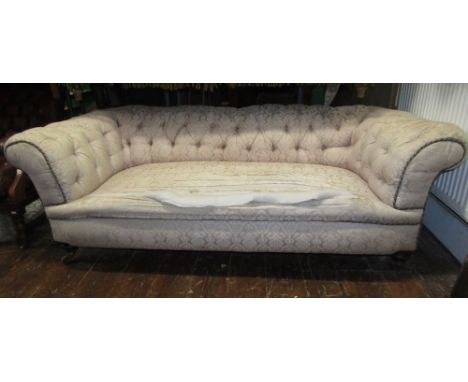 A Victorian two to three seat low Chesterfield sofa, with cream ground floral patterned upholstery, deep button back rolled a