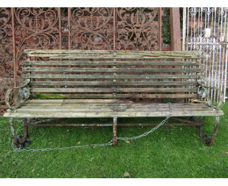 A vintage sprung steel framed garden/park bench with scrolled arms and weathered timber slatted seat and back, 7ft long appro