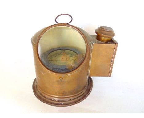 A copper cased ships binnacle compass with circular glass viewing panel and lamp box to the side, 21cm high