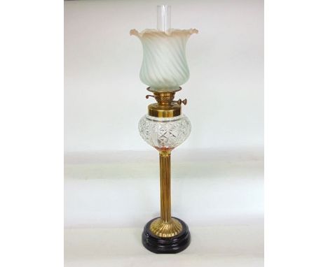 An impressive large brass and cut glass oil lamp with opaque lobed glass shade over a star cut glass well upon a Corinthian c