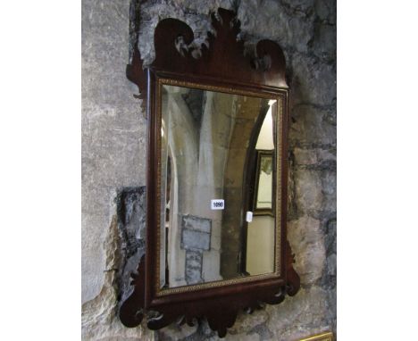 A Chippendale revival wall mirror of rectangular form with bevelled edge plate, gilt moulded slip, moulded and carved fretwor