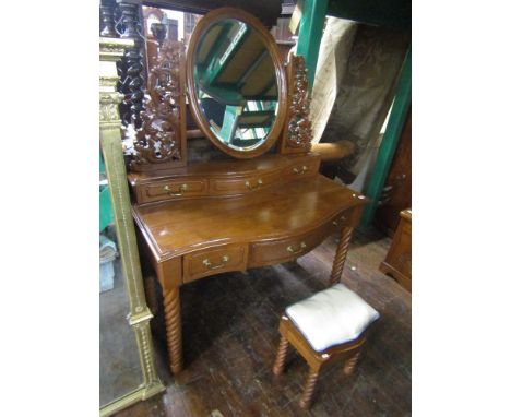 A contemporary hardwood dressing table with oval swing mirror, flanked by carved and pierced acanthus brackets, raised on a p