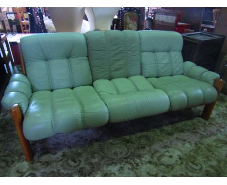 A 1980s Ekornes green leather safari sofa upon a teak frame. 