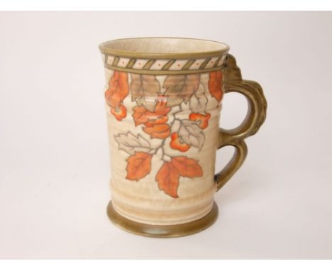 A Crown Ducal tankard designed by Charlotte Rhead with double looped handle and painted falling autumn leaf detail with paint