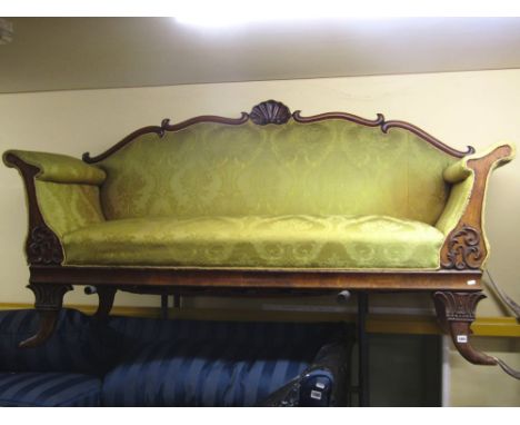 A 19th century three seat sofa, with yellow ground, floral patterned upholstery within a shaped, carved and moulded show wood