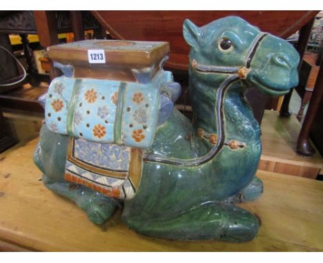 A Chinese ceramic garden seat in the form of a recumbent camel with glazed finish