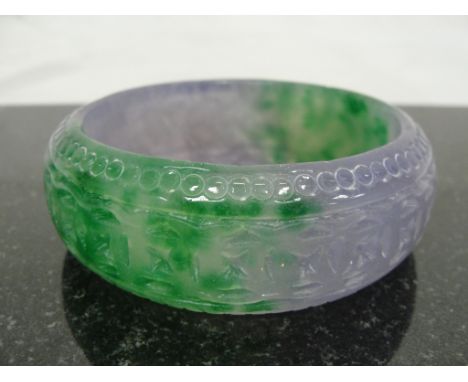 A Jadeite Green and Lilac Bangle with Engraved Decoration