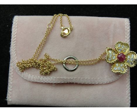 An 18ct diamond and ruby set floral pendant on an 18ct chain