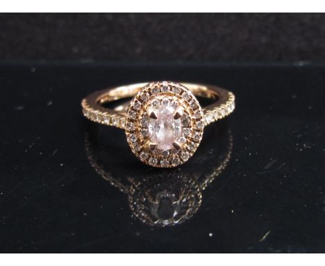 A rose gold diamond ring the centre stone .33ct framed by round brilliant cut diamonds and diamond set shoulders, with Insura