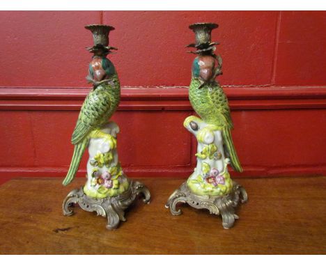 A pair of Victorian style ceramic candlesticks, bird form on brass bases, slight chip to beak to one candlestick, 37cm tall
