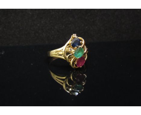 A gold ring set with oval blue sapphire, ruby and emerald and diamond chips, stamped 18k. Size L/M, 3.1g