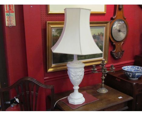A resin classical style table lamp base with scenes of putti and cream fluted shade