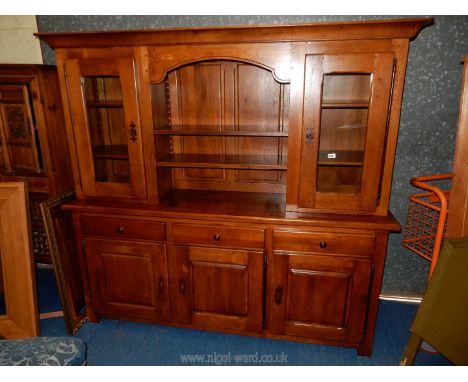 A contemporary peg-joyned Oak dresser having an arched central shelf area flanked by opposing glazed-doored cupboards with ad