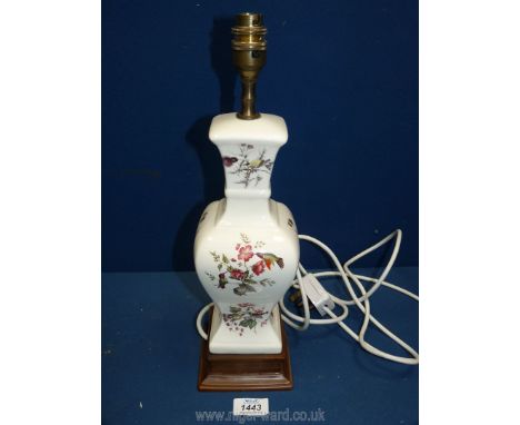 A china lamp base decorated with birds and flowers standing on a wooden base. 15 1/2" tall.