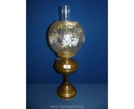 A Victorian oil lamp with clear globe, white with flowers, on brass base with chimney, 23" tall.