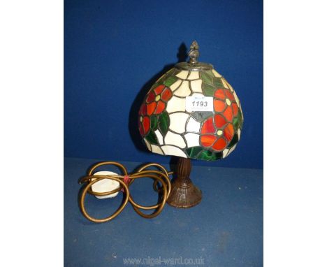 A small Tiffany style lamp, the glass shade decorated with red flowers and green foliage, 12'' tall (some panels cracked)