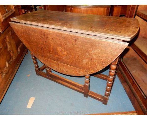 An Oak gate-leg drop-leaf table standing on elegant turned legs, 40 1/2'' x 15'' extending to an oval 48'' approximately x 27