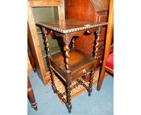 An early 20th c. dark Oak bedside table having mirrored twist legs and 'H' stretcher, the lower shelf with a drawer having a 