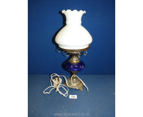 An oil lamp converted to electric with metal base, blue china reservoir and a white fluted rim shade, 15 1/2" tall.