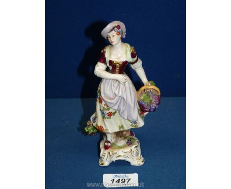 A German Rudolf Kammer of Volkstedt figurine of a lady holding a basket, with underglaze mark in blue of a crown over the let