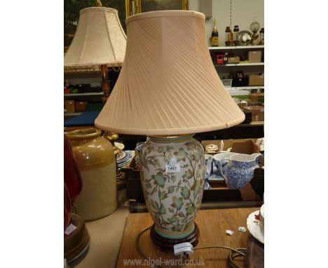 A china table lamp decorated in leaves with a cream shade. 26" tall.