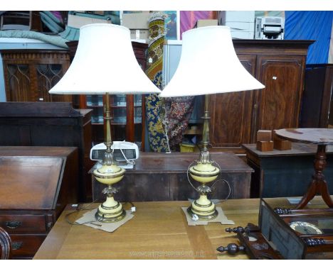 A pair of tall yellow and brass Art Deco style Lamps having petal decoration and a pair of large lamp shades.